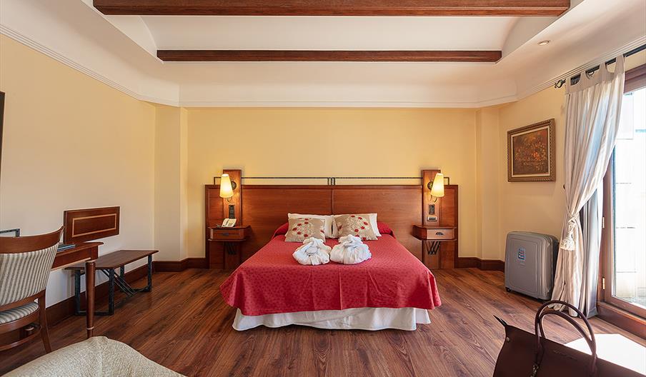Comfortable bed in the Junior Suite Deluxe at Hotel Abades Guadix, a four-star hotel in Guadix, Granada, Andalusia