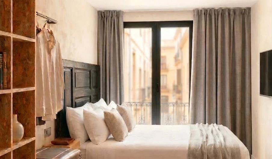 Habitación doble renovada del Hotel San Vicente en Conil con cama de matrimonio y balcón